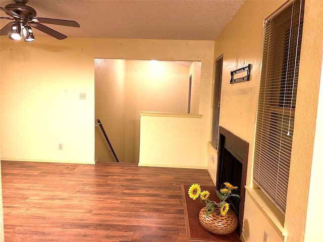 unfurnished living room with hardwood / wood-style flooring, ceiling fan, and a textured ceiling