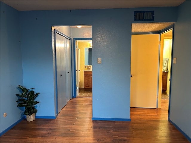 unfurnished bedroom with dark hardwood / wood-style floors and a closet