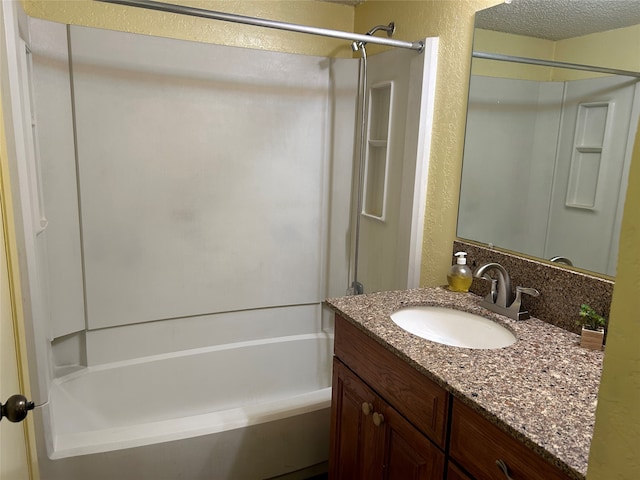 bathroom featuring vanity, a textured ceiling, and bathing tub / shower combination