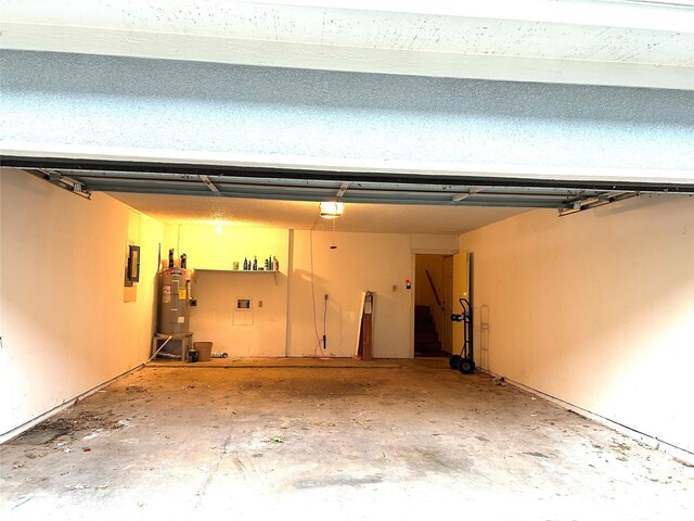 garage featuring electric panel, a garage door opener, and water heater