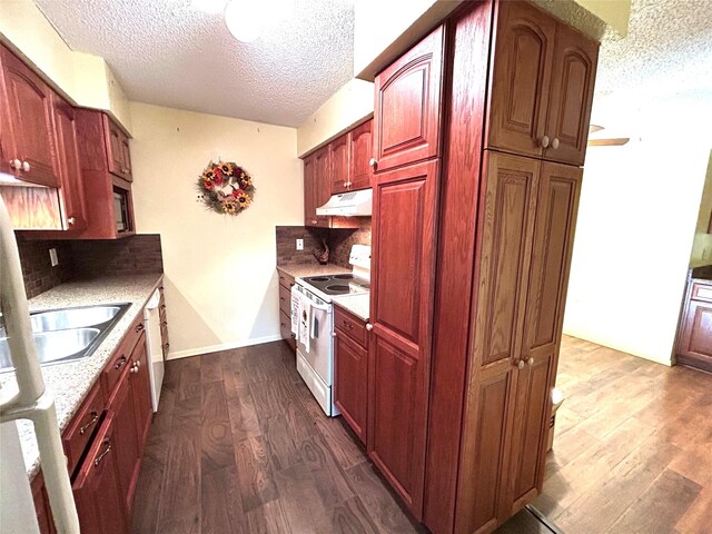 kitchen featuring sink, dark wood-type flooring, tasteful backsplash, a textured ceiling, and white appliances