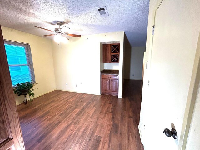 empty room featuring a textured ceiling and dark wood-type flooring