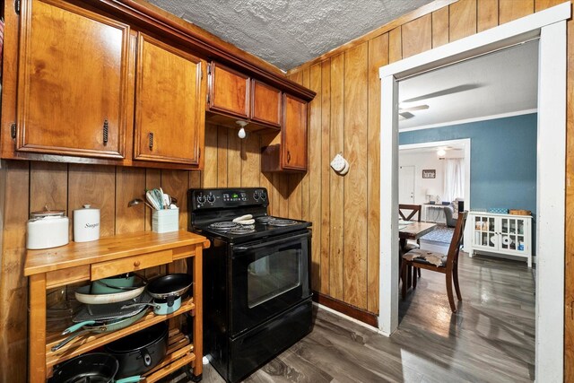 kitchen featuring electric range, wood walls, ornamental molding, and dark wood-type flooring