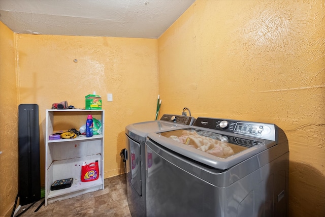 washroom featuring washing machine and clothes dryer and a textured ceiling