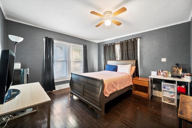 bedroom featuring dark hardwood / wood-style flooring, ceiling fan, and crown molding