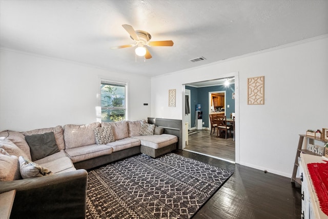 living room featuring dark hardwood / wood-style flooring, ceiling fan, and ornamental molding