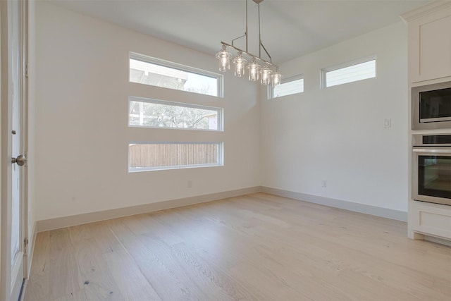 unfurnished dining area featuring light wood-type flooring