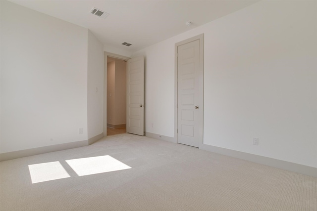 spare room featuring light colored carpet