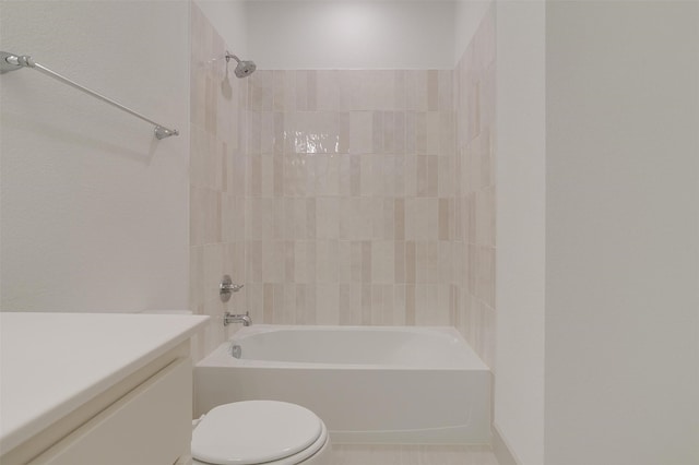 full bathroom featuring vanity, tiled shower / bath, and toilet