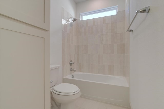 bathroom featuring tiled shower / bath combo and toilet