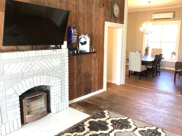 living room with a brick fireplace, an AC wall unit, crown molding, hardwood / wood-style floors, and wooden walls