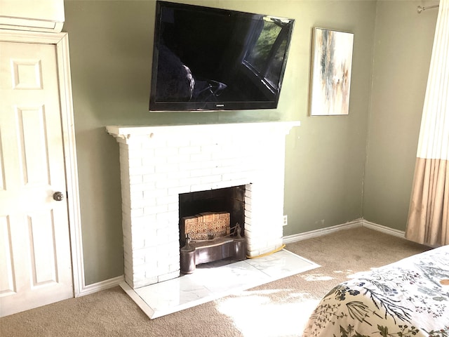 carpeted bedroom with a brick fireplace and a wall mounted AC