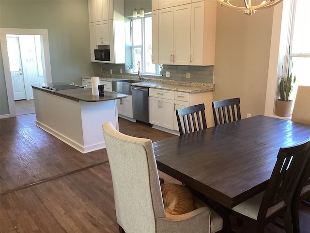 kitchen with white cabinetry, dishwasher, dark hardwood / wood-style flooring, backsplash, and a kitchen island