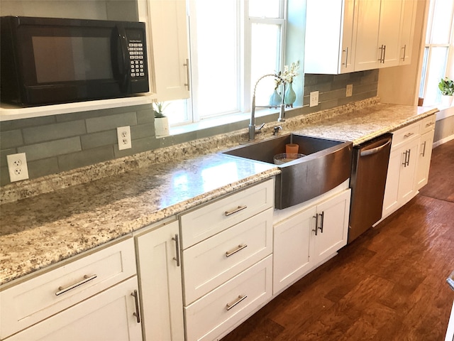 kitchen featuring stainless steel dishwasher, decorative backsplash, plenty of natural light, and dark wood-type flooring