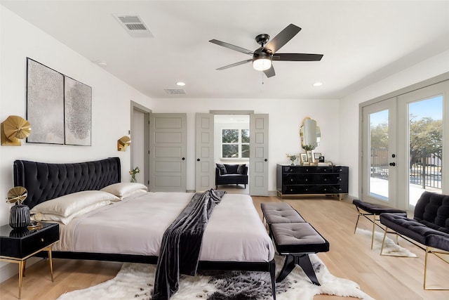 bedroom featuring access to exterior, wood finished floors, visible vents, and multiple windows