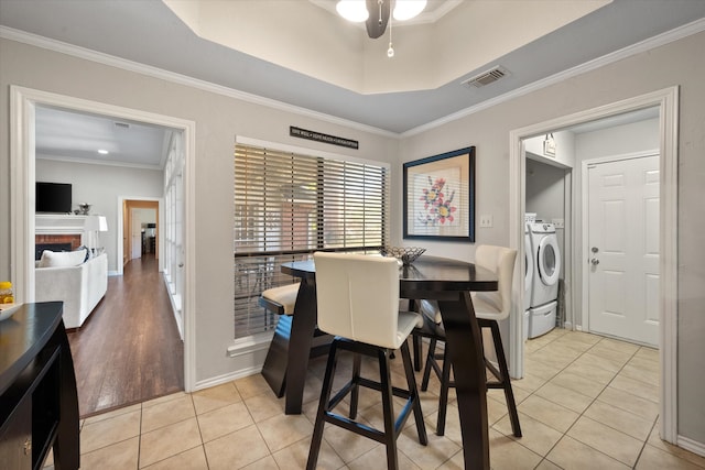 dining area featuring ceiling fan, a raised ceiling, ornamental molding, and light tile patterned floors