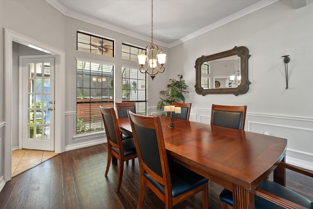 dining area with wood-type flooring, an inviting chandelier, and ornamental molding