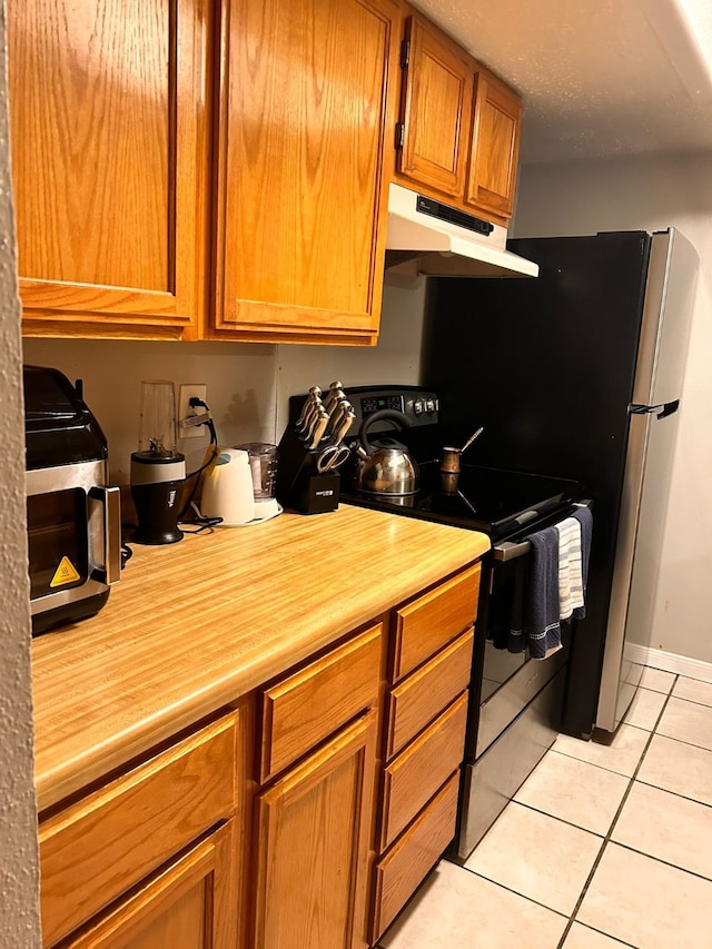 kitchen featuring electric stove and light tile patterned floors