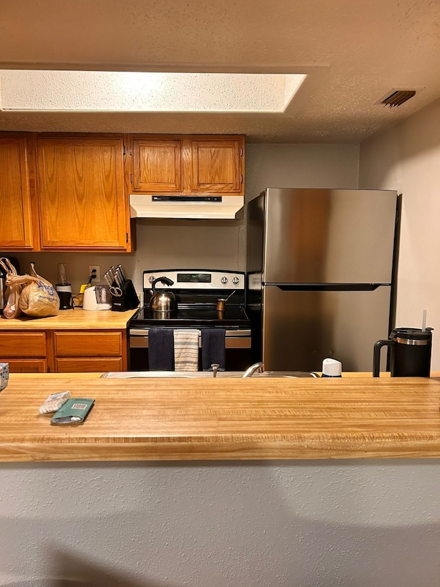 kitchen featuring a textured ceiling and stainless steel appliances