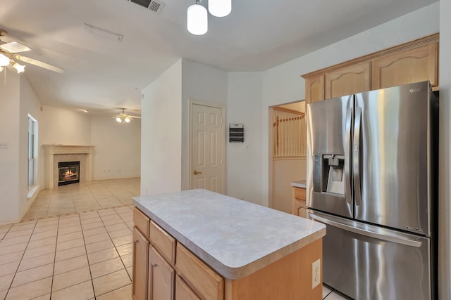 kitchen with ceiling fan, a center island, light brown cabinets, stainless steel refrigerator with ice dispenser, and light tile patterned flooring