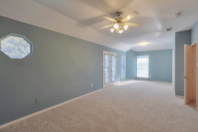 carpeted spare room featuring vaulted ceiling and ceiling fan