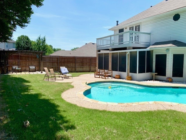 view of swimming pool with a fenced in pool, fence, a lawn, a sunroom, and a patio