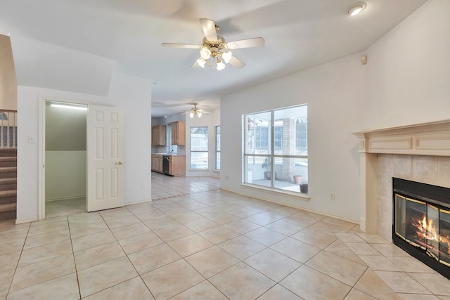 unfurnished living room featuring ceiling fan, light tile patterned floors, and a fireplace