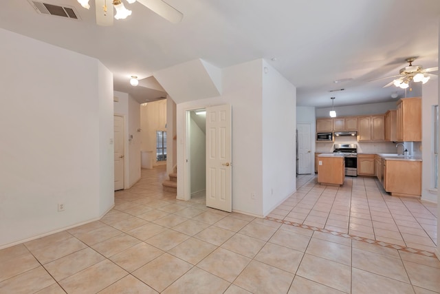 kitchen featuring a center island, sink, ceiling fan, light tile patterned floors, and appliances with stainless steel finishes