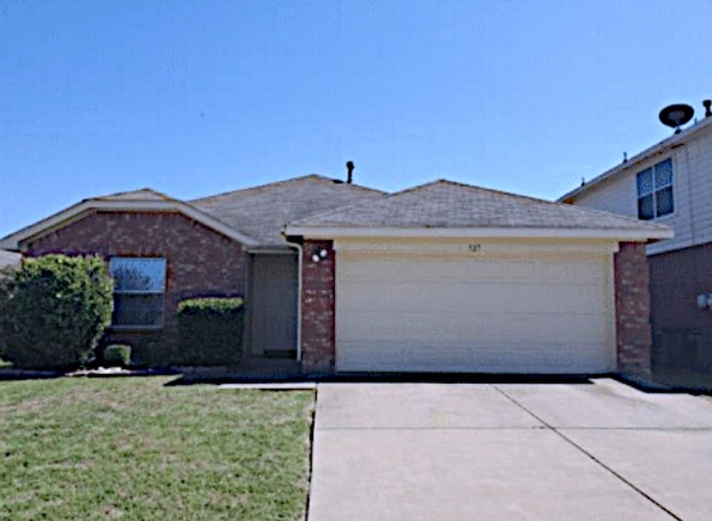 view of front of house with a garage and a front lawn