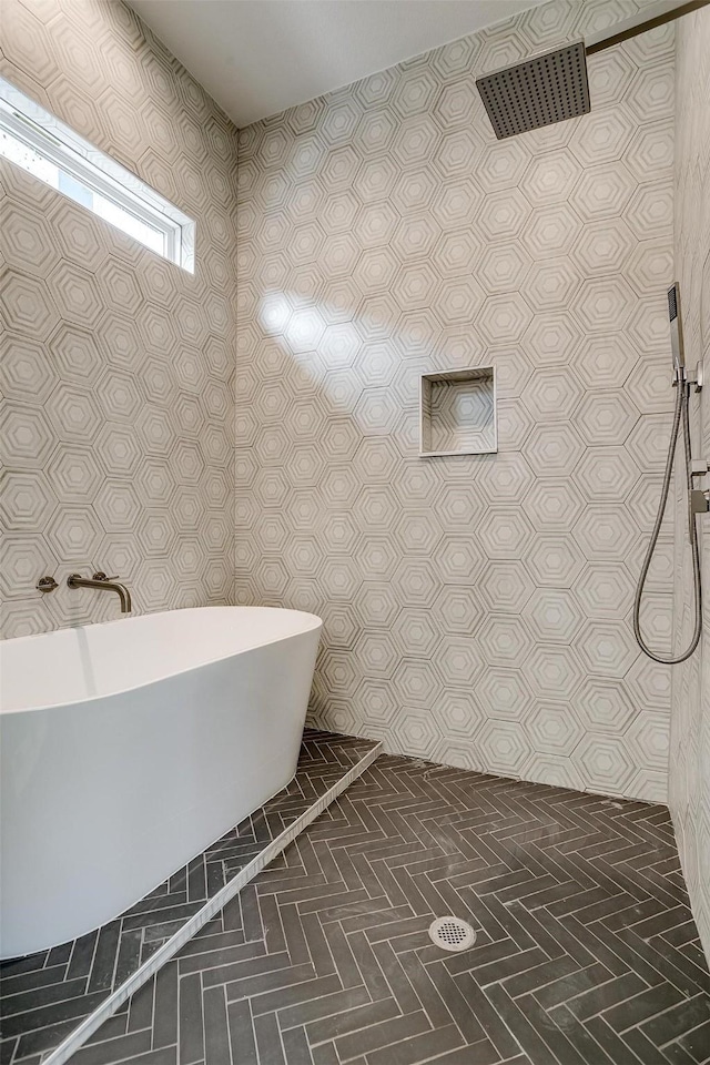 bathroom featuring a freestanding bath, tiled shower, and tile patterned flooring