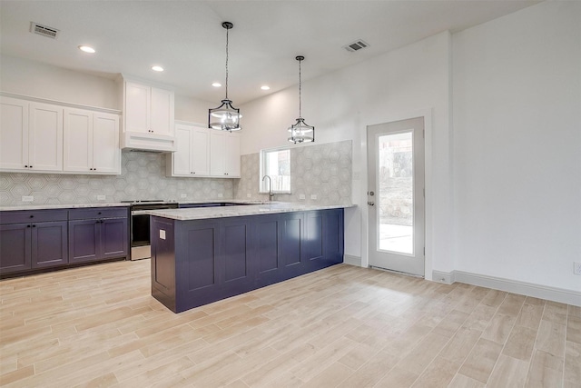 kitchen with decorative light fixtures, white cabinets, decorative backsplash, stainless steel range with electric stovetop, and kitchen peninsula