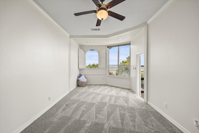 spare room featuring ceiling fan, ornamental molding, and light carpet