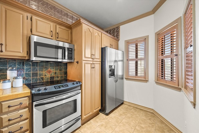 kitchen with tasteful backsplash, ornamental molding, stainless steel appliances, light brown cabinets, and light tile patterned floors