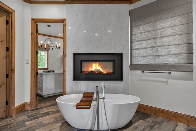 bathroom featuring crown molding, a bathtub, an inviting chandelier, and hardwood / wood-style flooring