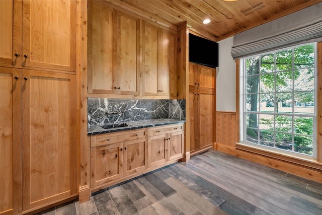 kitchen with dark stone counters, wood walls, wood ceiling, and dark hardwood / wood-style floors