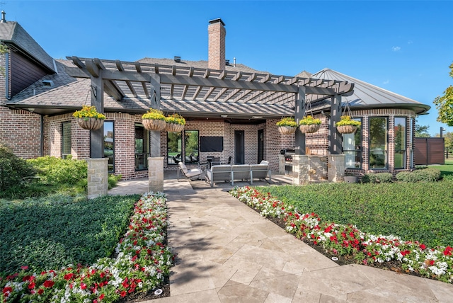 rear view of house featuring a pergola, an outdoor hangout area, and a patio area