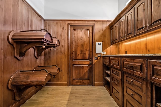 interior space with wooden walls and light hardwood / wood-style flooring