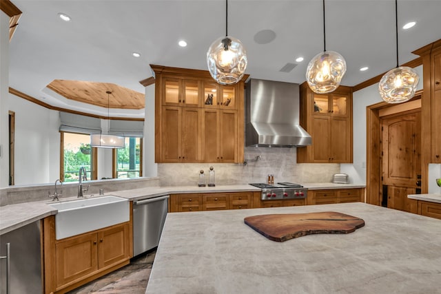 kitchen featuring sink, crown molding, wall chimney exhaust hood, decorative light fixtures, and stainless steel appliances