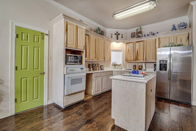 kitchen with appliances with stainless steel finishes, a center island, ornamental molding, and dark wood-type flooring