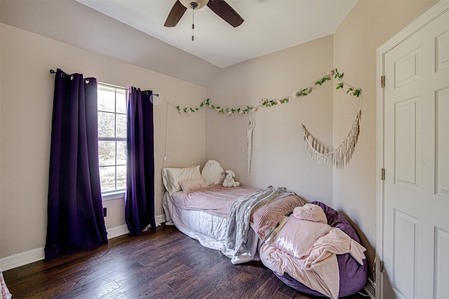 bedroom with dark hardwood / wood-style flooring, vaulted ceiling, and ceiling fan