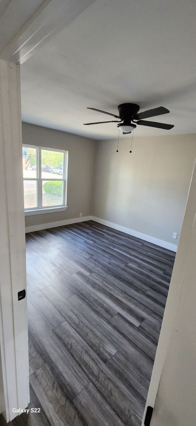 unfurnished room featuring ceiling fan and dark wood-type flooring