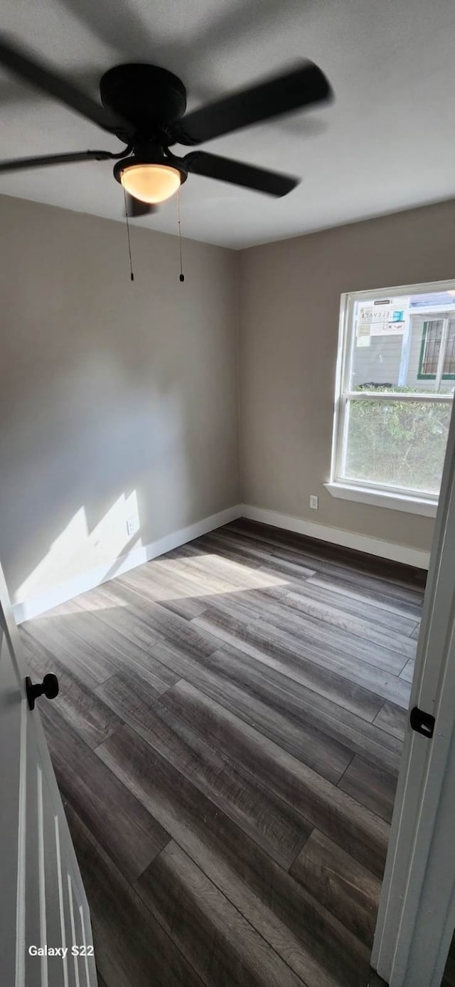 unfurnished room featuring ceiling fan and dark wood-type flooring