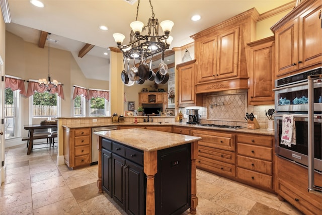 kitchen with a kitchen island, kitchen peninsula, stainless steel appliances, and an inviting chandelier