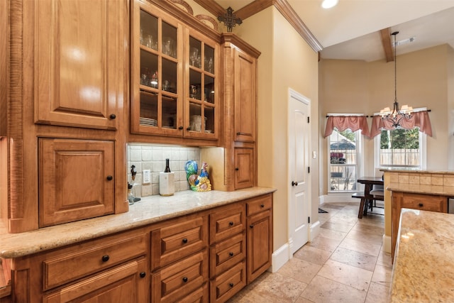 kitchen featuring light stone countertops, decorative backsplash, ornamental molding, pendant lighting, and a notable chandelier