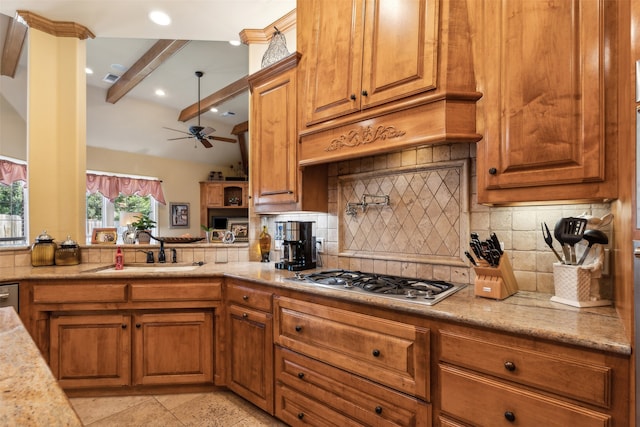 kitchen featuring backsplash, ceiling fan, stainless steel gas cooktop, sink, and beam ceiling