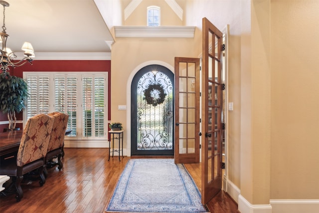 foyer with crown molding, a wealth of natural light, french doors, and dark wood-type flooring