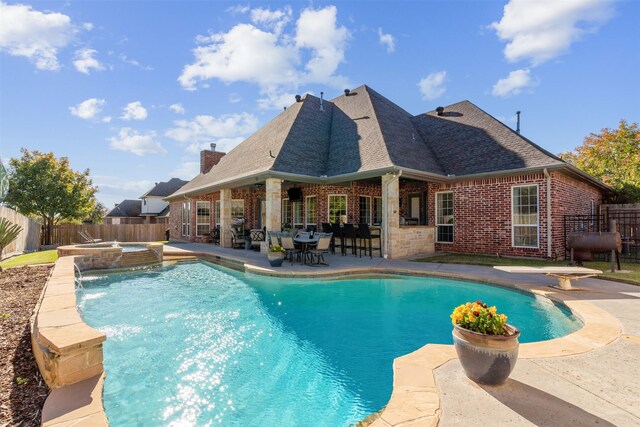 view of swimming pool with pool water feature, an in ground hot tub, and a patio