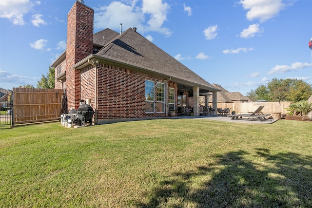 back of property with a yard and a patio