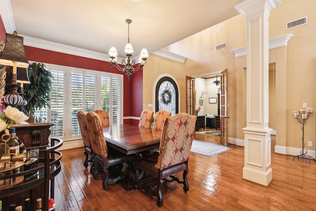 dining space featuring light hardwood / wood-style flooring, ornamental molding, and an inviting chandelier