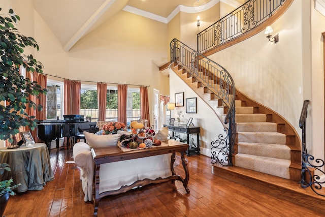 living room with wood-type flooring, crown molding, and high vaulted ceiling